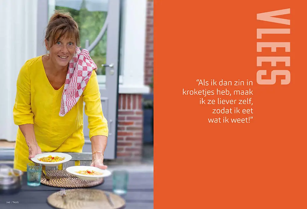Een dubbele pagina uit een kookboek: links een foto van een vrouw die twee borden op tafel zet, rechts een oranje vlak met het woord VLEES en een citaat van de auteur