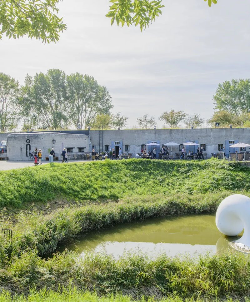 Het terras van het Kunstfort Vijfhuizen met links op de muur het logo van het restaurant ontworpen door Michael Kolf van Codex